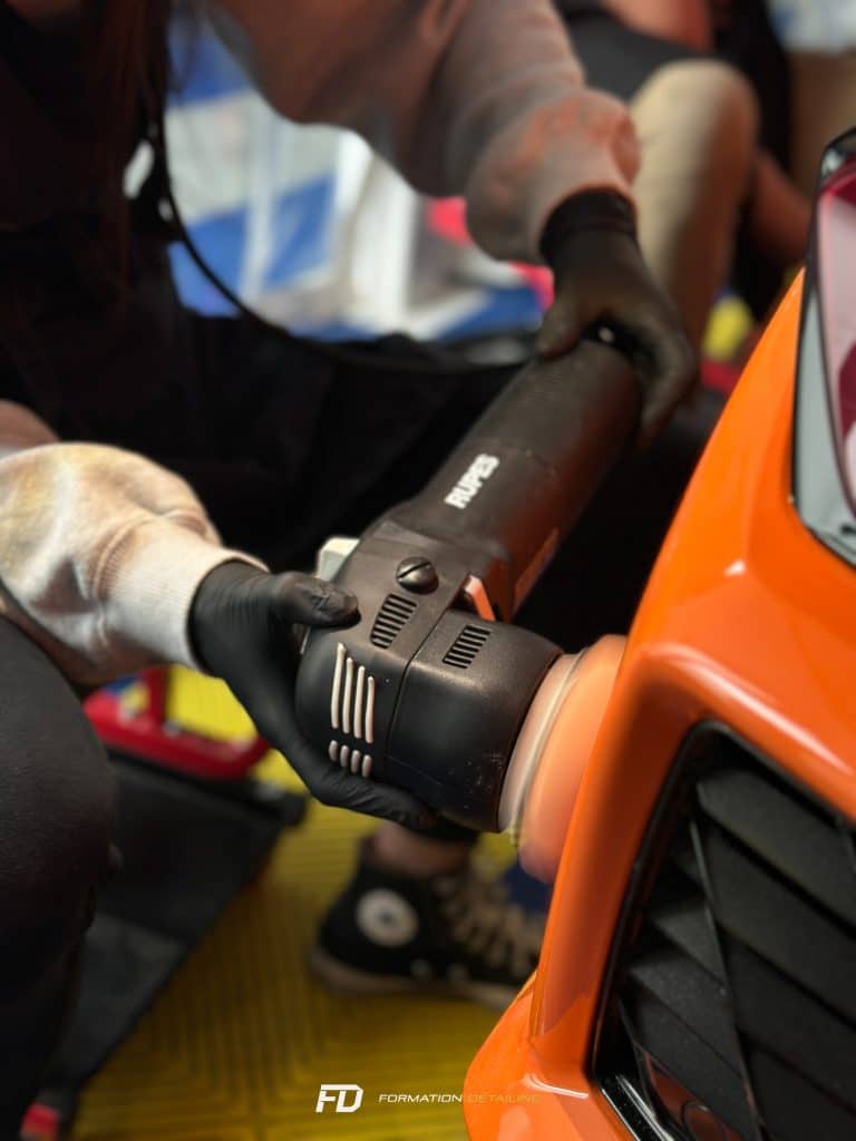 Personne travaillant sur un véhicule orange